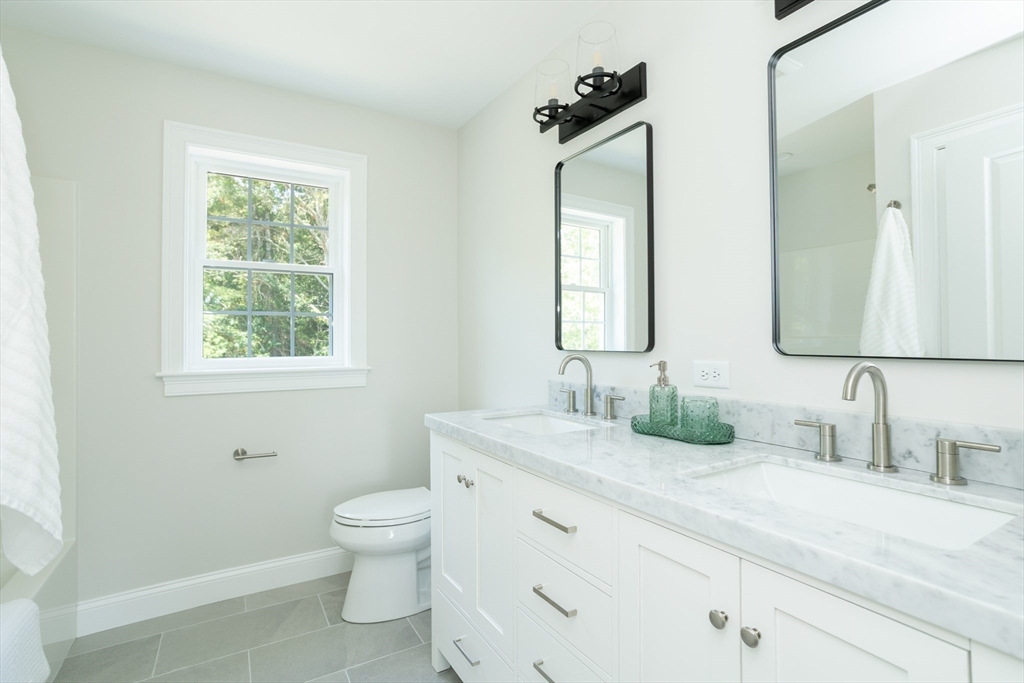 65 Great Neck Road Wareham, MA 02571 - Photo 38 of 41 a bathroom with a double vanity sink toilet and a mirror