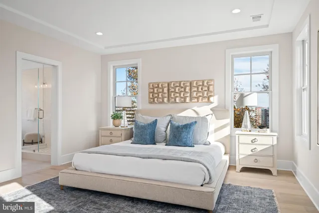 a spacious bedroom with a bed a mirror and dresser