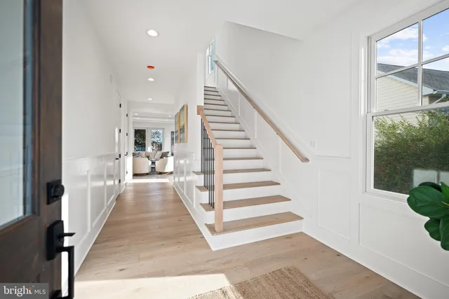 a view of a hallway with wooden floor and staircase