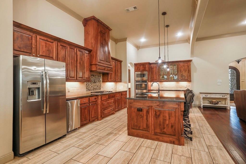1387 Shadow Lakes Drive Wills Point, TX 75169 - Photo 9 of 33 a kitchen with stainless steel appliances granite countertop a refrigerator a stove and a wooden floors
