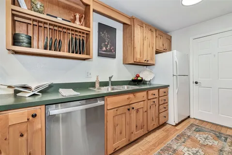 a kitchen with stainless steel appliances granite countertop a sink and cabinets with wooden floor
