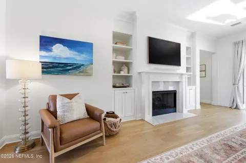 a dining room with furniture a chandelier and wooden floor