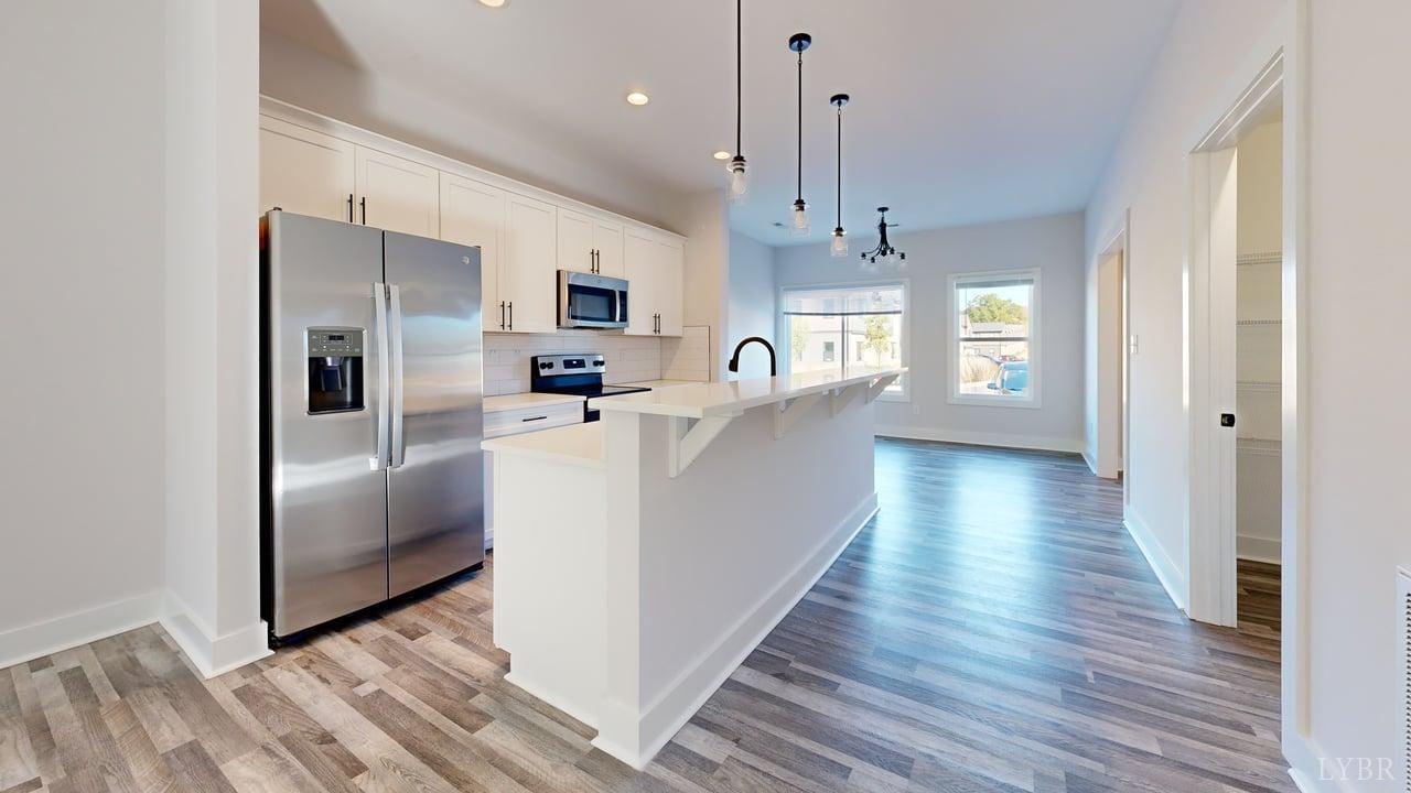 128 Allure Drive Rustburg, VA 24588 - Photo 6 of 30 a kitchen with stainless steel appliances granite countertop a refrigerator a sink dishwasher a stove and white countertops with wooden floor