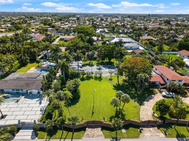 an aerial view of residential houses with outdoor space and ocean view