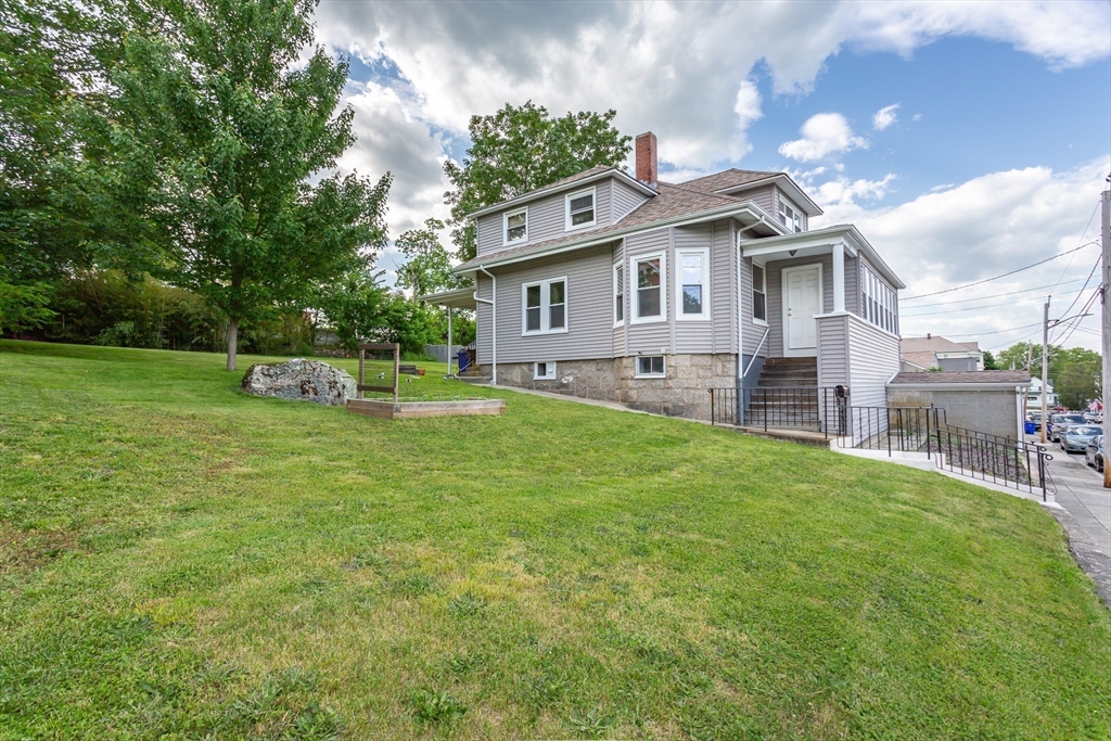 123 Huard Street Fall River, MA 02721 - Photo 4 of 26 a front view of a house with a yard and trees