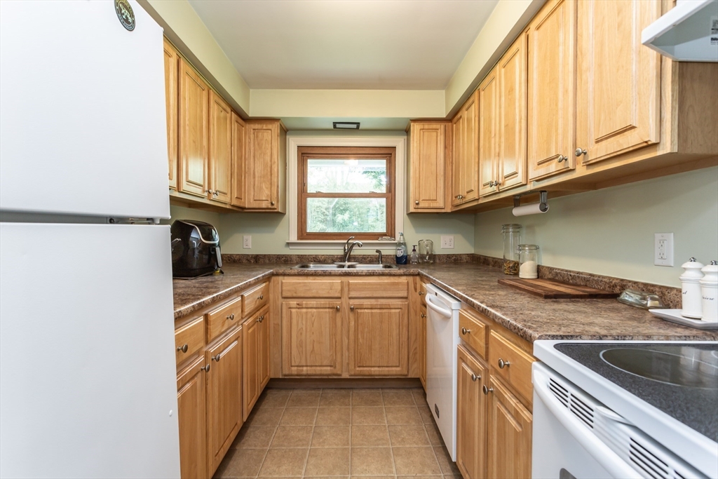 123 Huard Street Fall River, MA 02721 - Photo 8 of 26 a kitchen with stainless steel appliances granite countertop a sink and a refrigerator