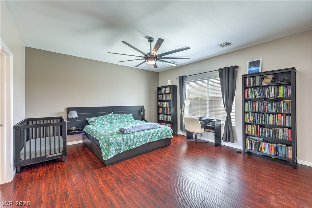 580 Lillian Condie Road Overton, NV 89040 - Photo 20 of 37 Rich hardwood flooring grounds this well-lit bedroom featuring a large window, ample natural light, and a stylish ceiling fan.