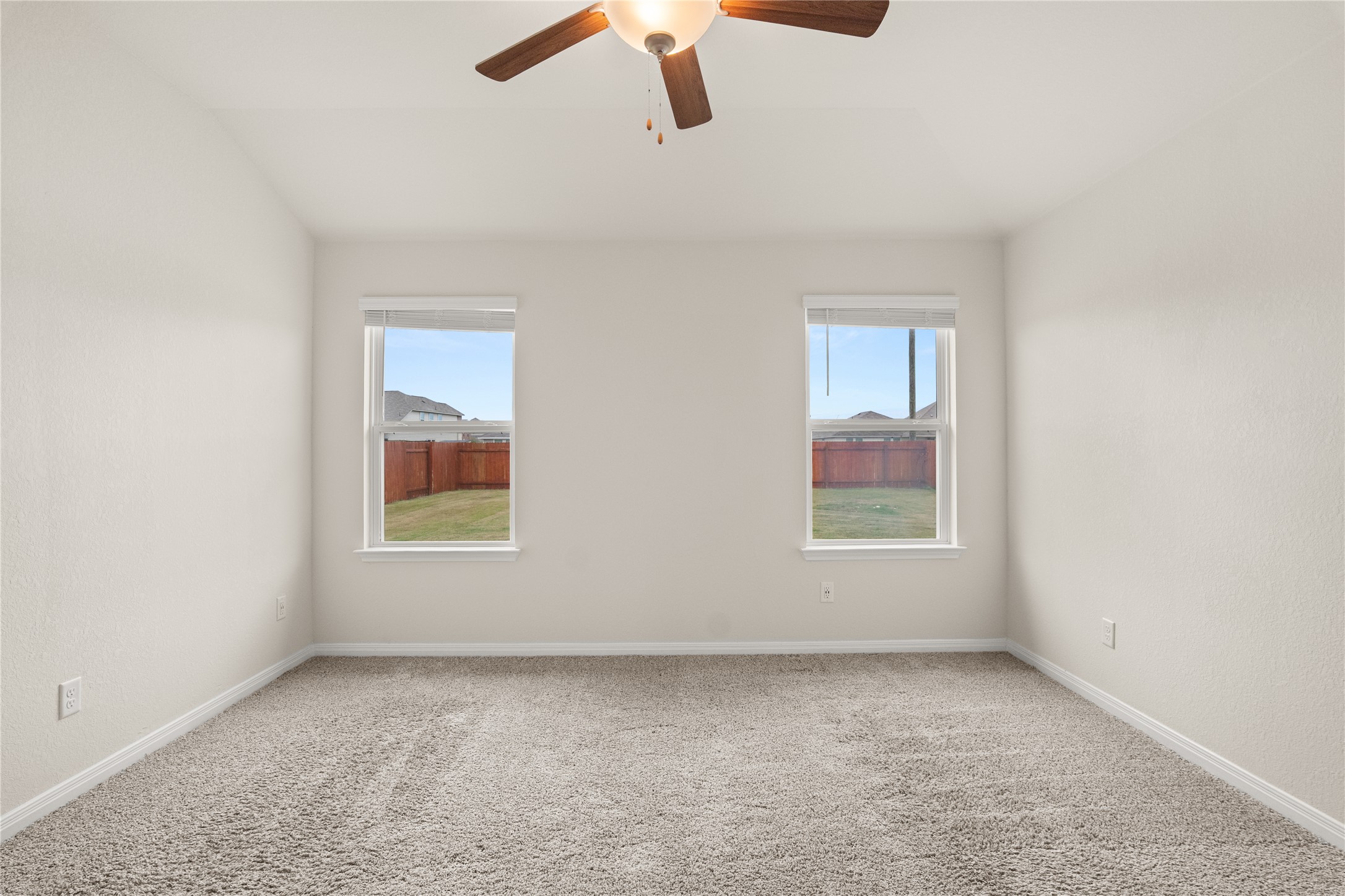105 Saviano Road Hutto, TX 78634 - Photo 9 of 22 Primary Bedroom: A comfortable bedroom with plush carpet and well-lit by two large windows.