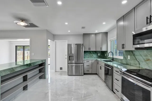 a kitchen with stainless steel appliances granite countertop a stove refrigerator and microwave