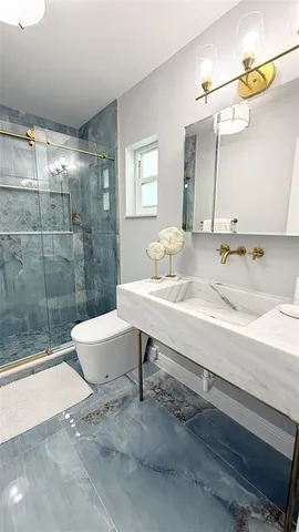 a bathroom with a sink a toilet and shower