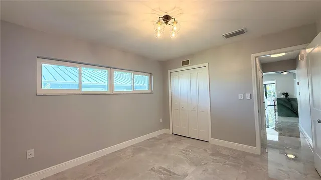 an empty room with windows and closet