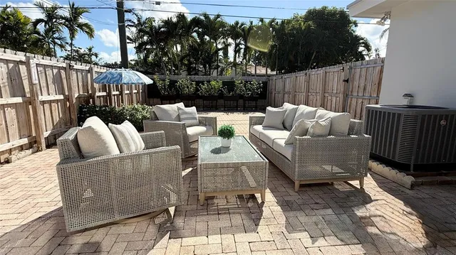 a view of a patio with couches chairs and wooden floor