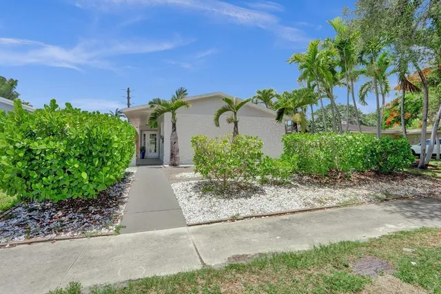 front view of house with a yard and potted plants