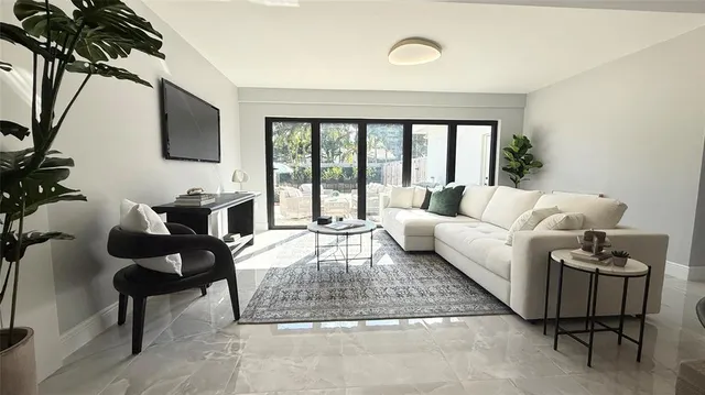 a living room with furniture and a floor to ceiling window