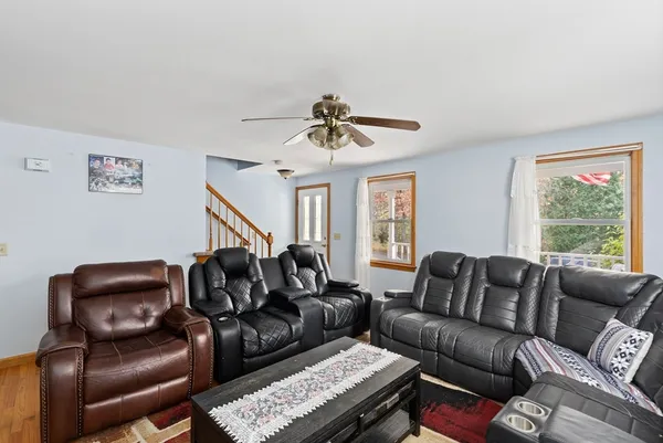 a living room with furniture ceiling fan and a window