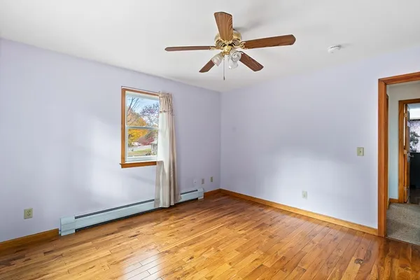 a view of empty room with wooden floor