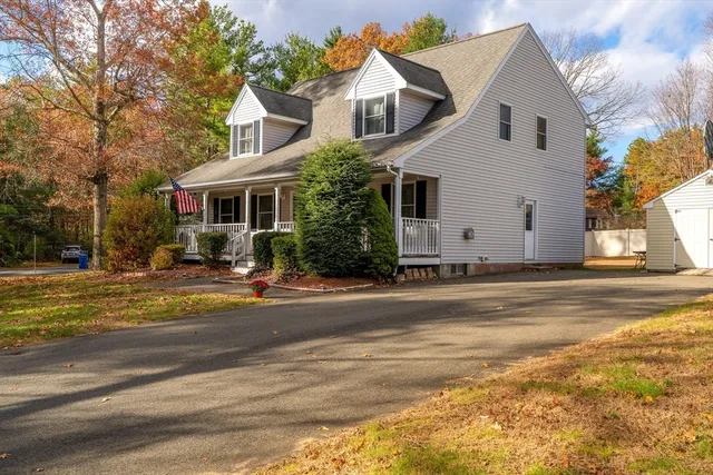 a view of a white house with a yard next to a road
