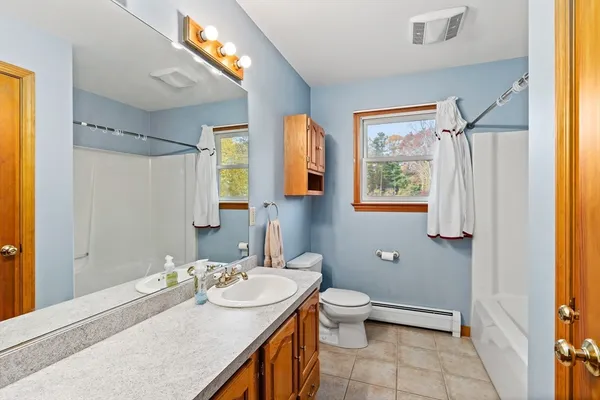 a bathroom with a granite countertop sink toilet and shower