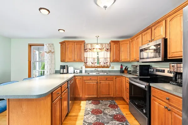 a kitchen with stainless steel appliances granite countertop sink stove top oven and cabinets