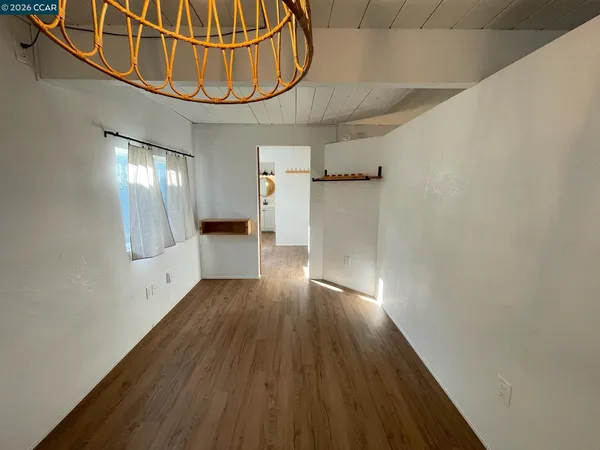 a view of an empty room with wooden floor