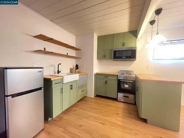 a kitchen with a wooden floor and a stainless steel appliances