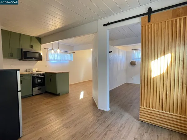 a view of kitchen with wooden floor and electronic appliances