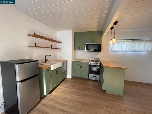 a kitchen with a refrigerator wooden floor and a sink