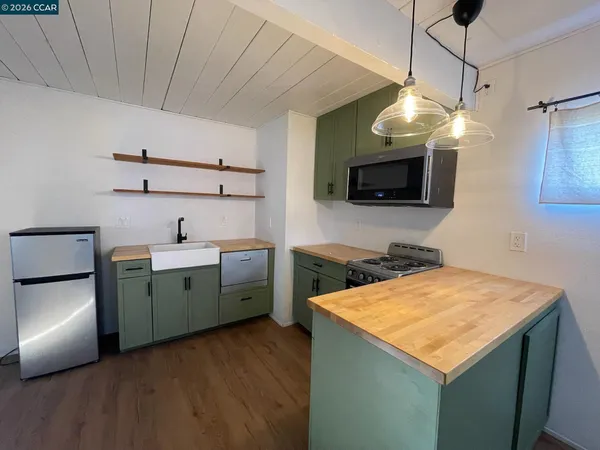 a kitchen with a sink a microwave a stove and refrigerator