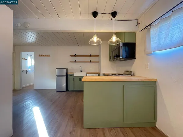 a kitchen with a sink and wooden floor