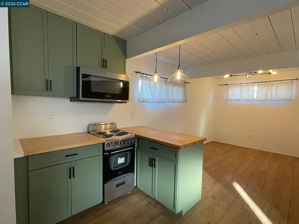 a kitchen with stainless steel appliances white cabinets and a stove top oven