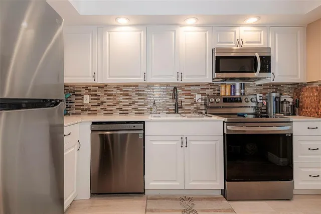 a kitchen with stainless steel appliances granite countertop a stove top oven microwave and cabinets