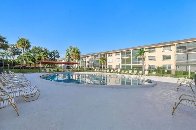 a view of swimming pool with outdoor seating and a garden