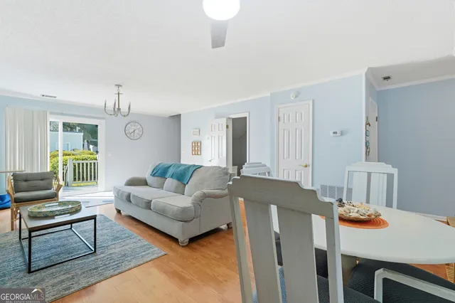 a living room with furniture a dining table and a window