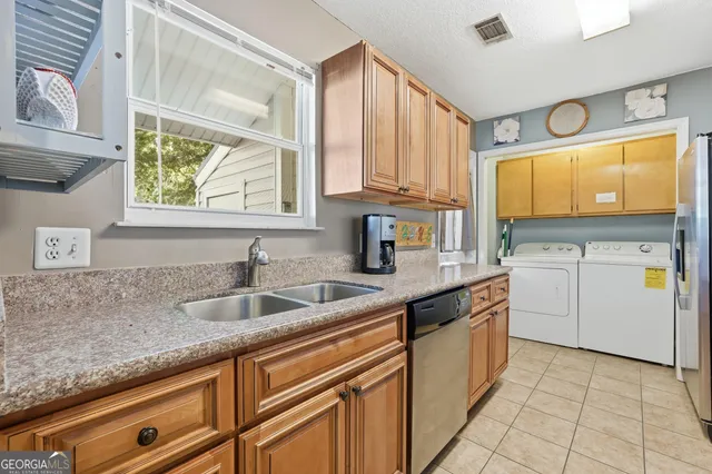a kitchen with stainless steel appliances granite countertop a refrigerator and a sink