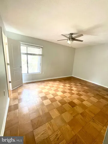 an empty room with windows and fan