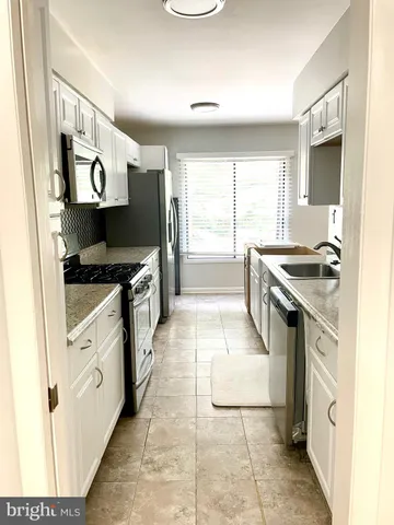 a kitchen with stainless steel appliances granite countertop a stove and a sink