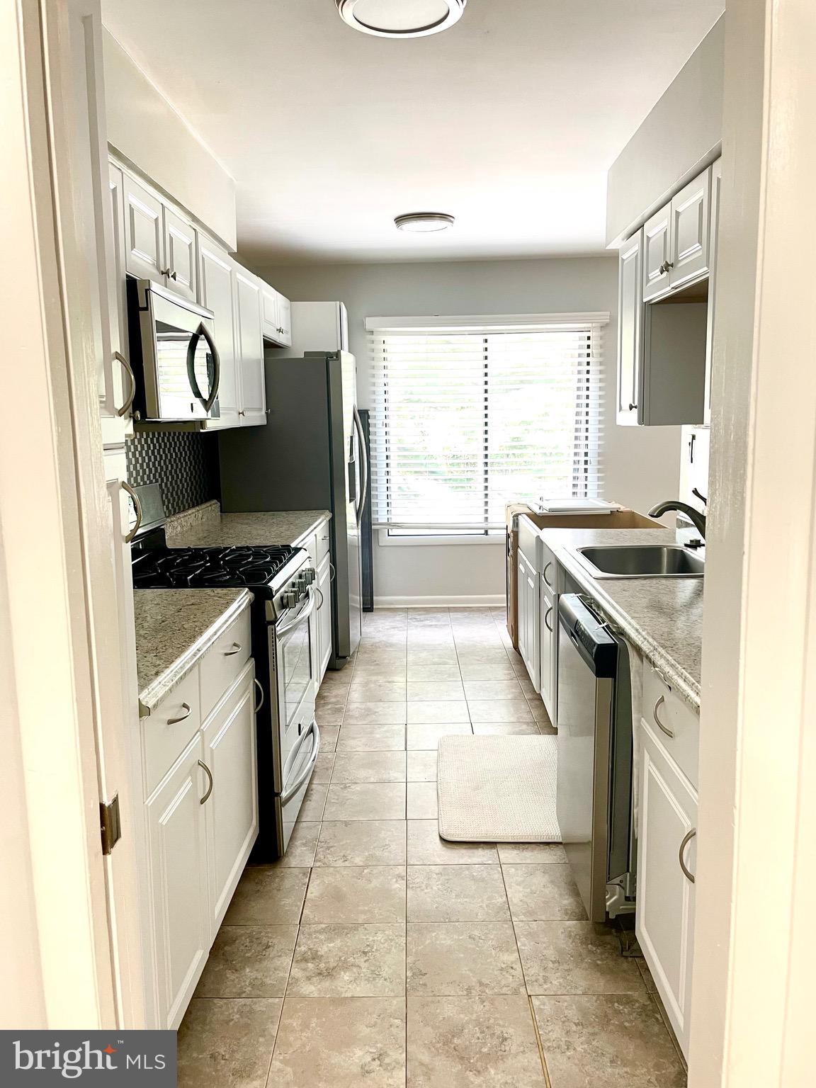 5234 West Running Brook Road, Unit 301 Columbia, MD 21044 - Photo 13 of 13 a kitchen with stainless steel appliances granite countertop a stove and a sink