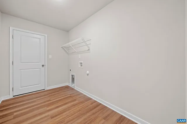 an empty room with a chandelier fan and windows