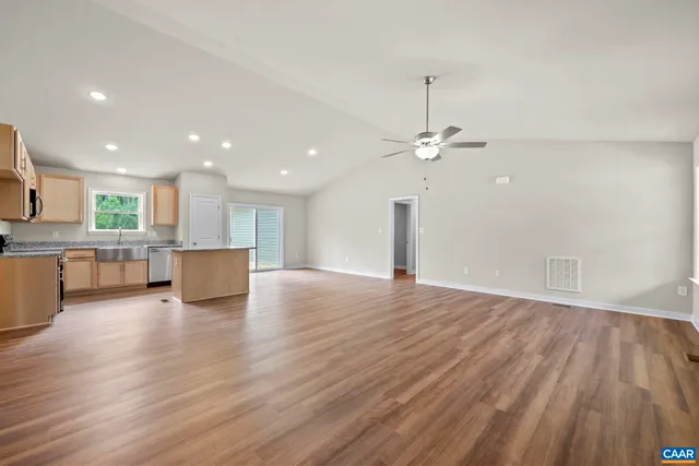 a view of empty room with wooden floor and window