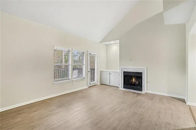 a view of an empty room with a fireplace and a window