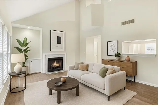 a living room with furniture a fireplace and a potted plant