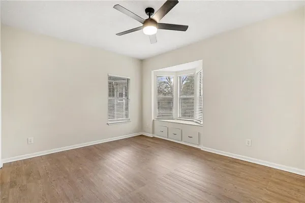 a view of wooden floor and a chandelier fan in a room
