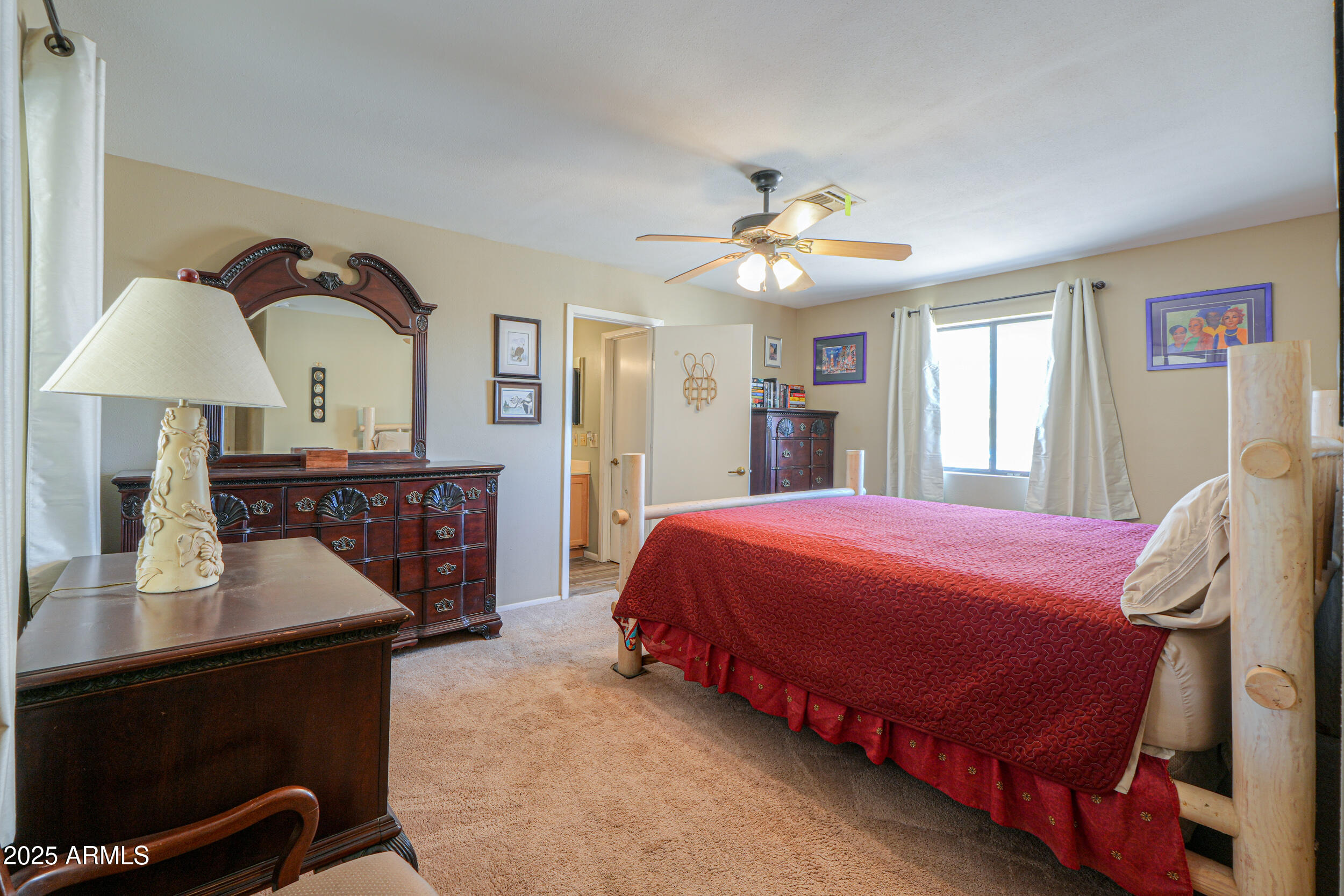 209 South Hidden Valley Road Maricopa, AZ 85139 - Photo 16 of 39 a bedroom with a bed and a chandelier