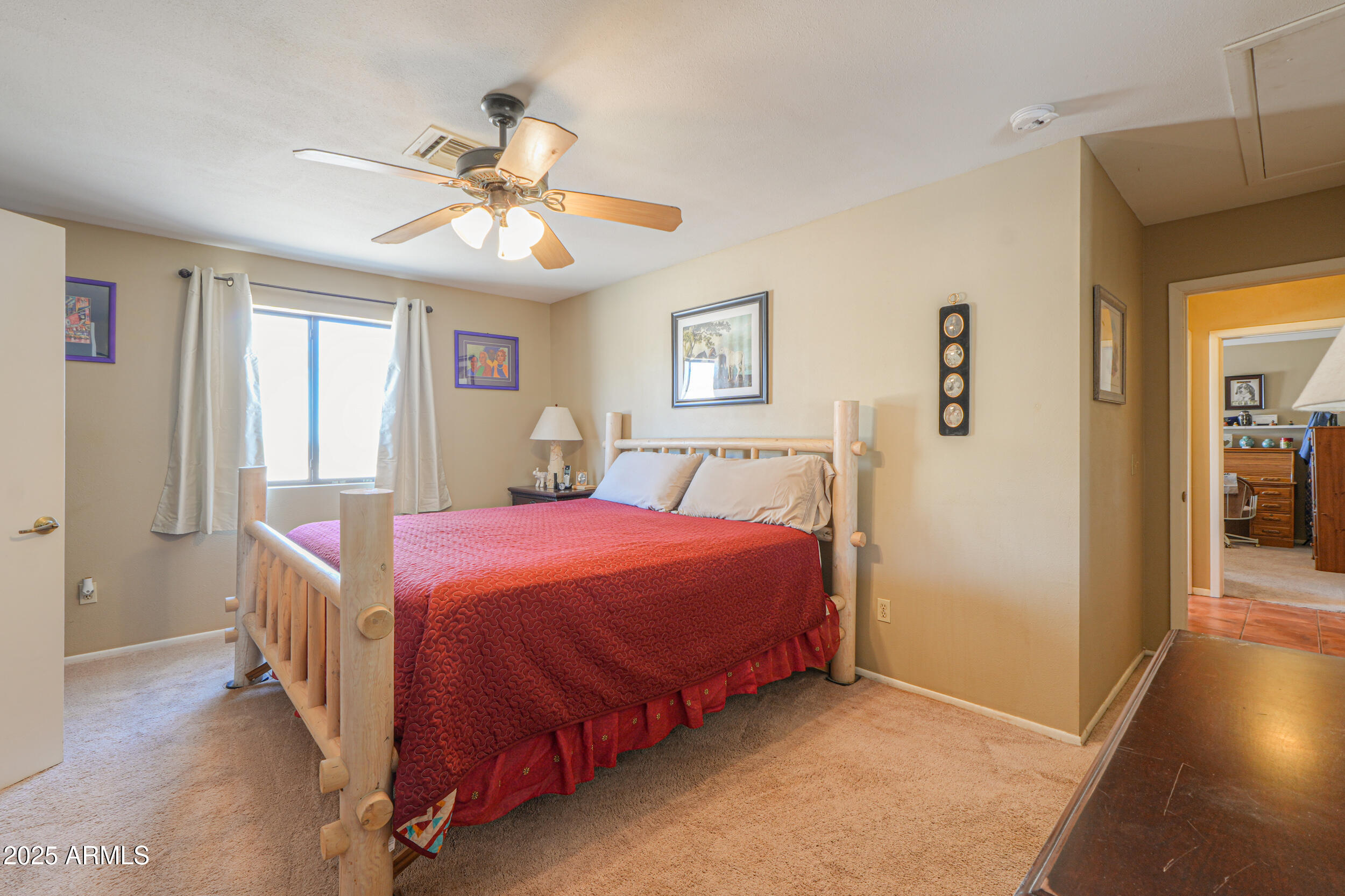 209 South Hidden Valley Road Maricopa, AZ 85139 - Photo 17 of 39 a bedroom with a bed and a chandelier