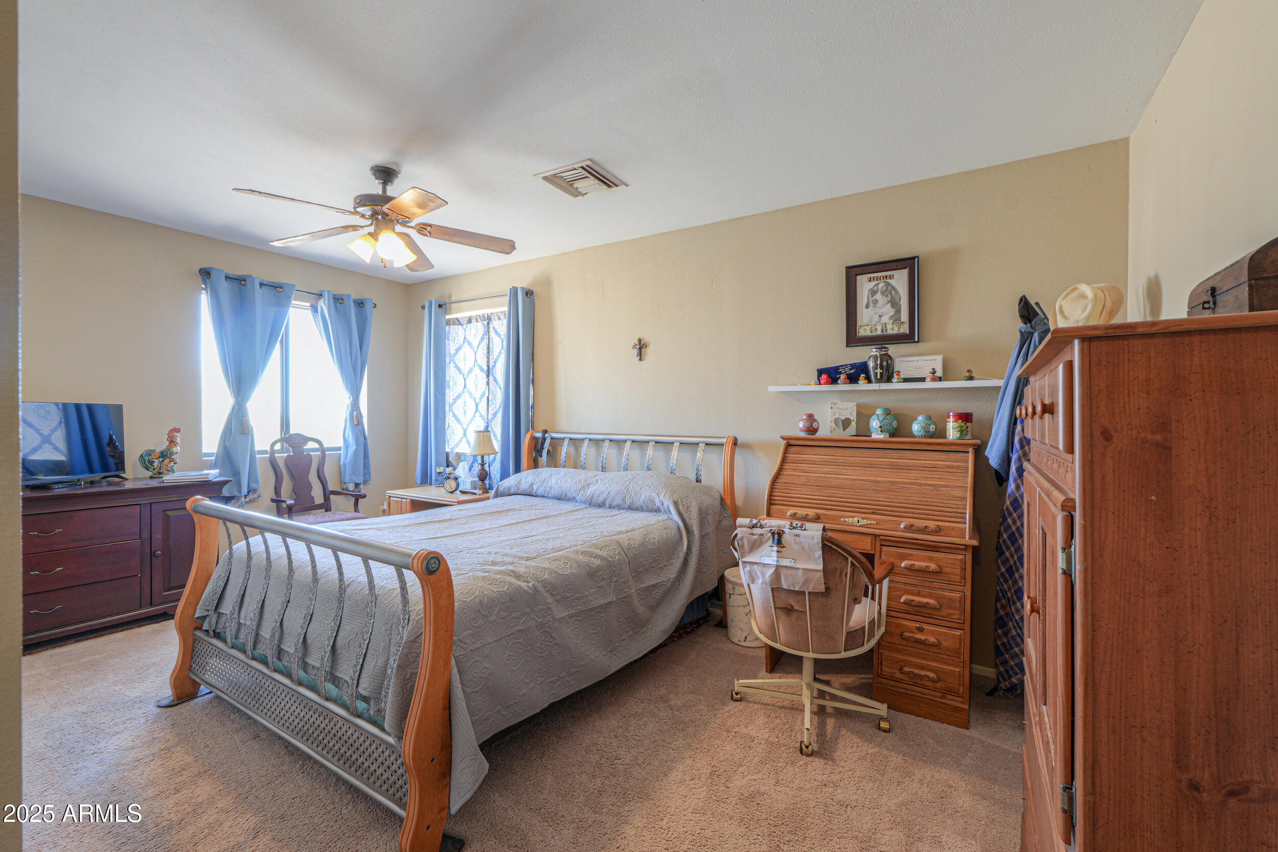 209 South Hidden Valley Road Maricopa, AZ 85139 - Photo 22 of 39 a bedroom with a bed a chandelier and a dresser