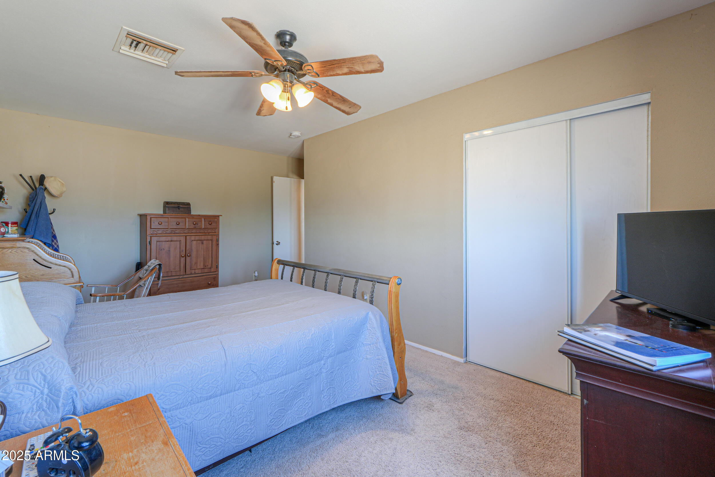 209 South Hidden Valley Road Maricopa, AZ 85139 - Photo 23 of 39 a bedroom with a bed and a television