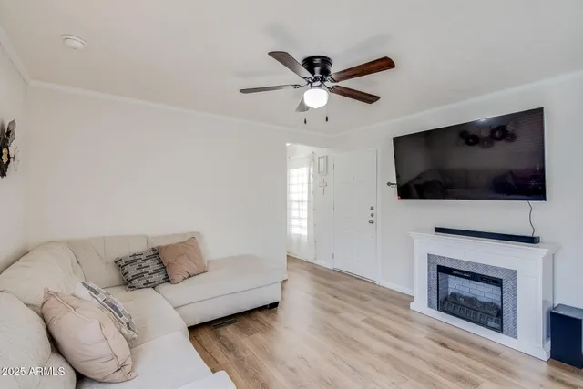 a living room with furniture a flat screen tv and a fireplace