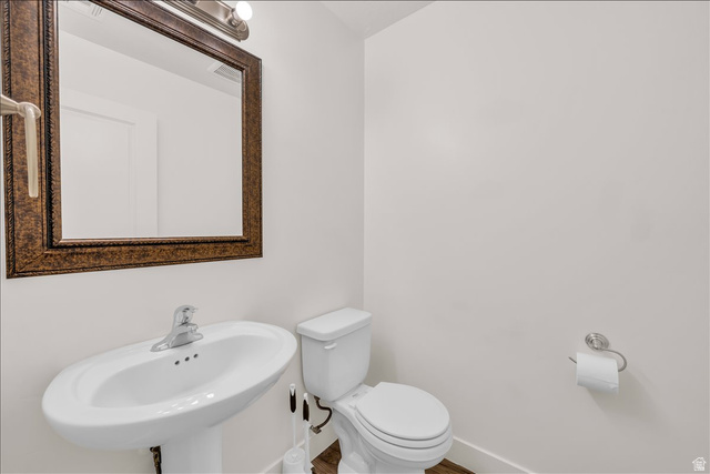 5875 Challenger Way St. George, UT 84790 - Photo 16 of 18 Pedestal sink with a polished chrome faucet, set beneath a framed mirror with an overhead vanity light