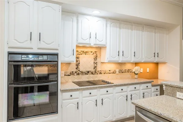 a kitchen with white cabinets and refrigerator
