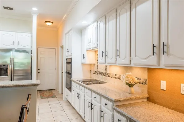 a kitchen with a sink dishwasher a dining table and chairs with wooden floor